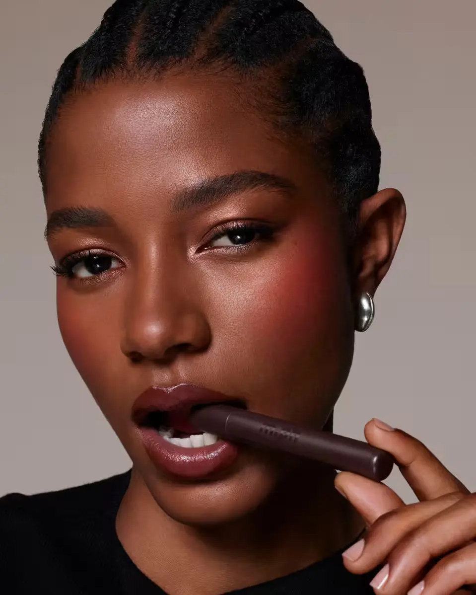 Woman holding a chocolate bar against a neutral background