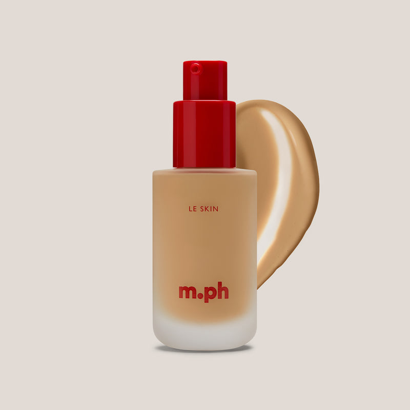 M.PH Le Skin olive-toned weightless foundation in shade 80 with a golden swatch behind the frosted glass bottle.