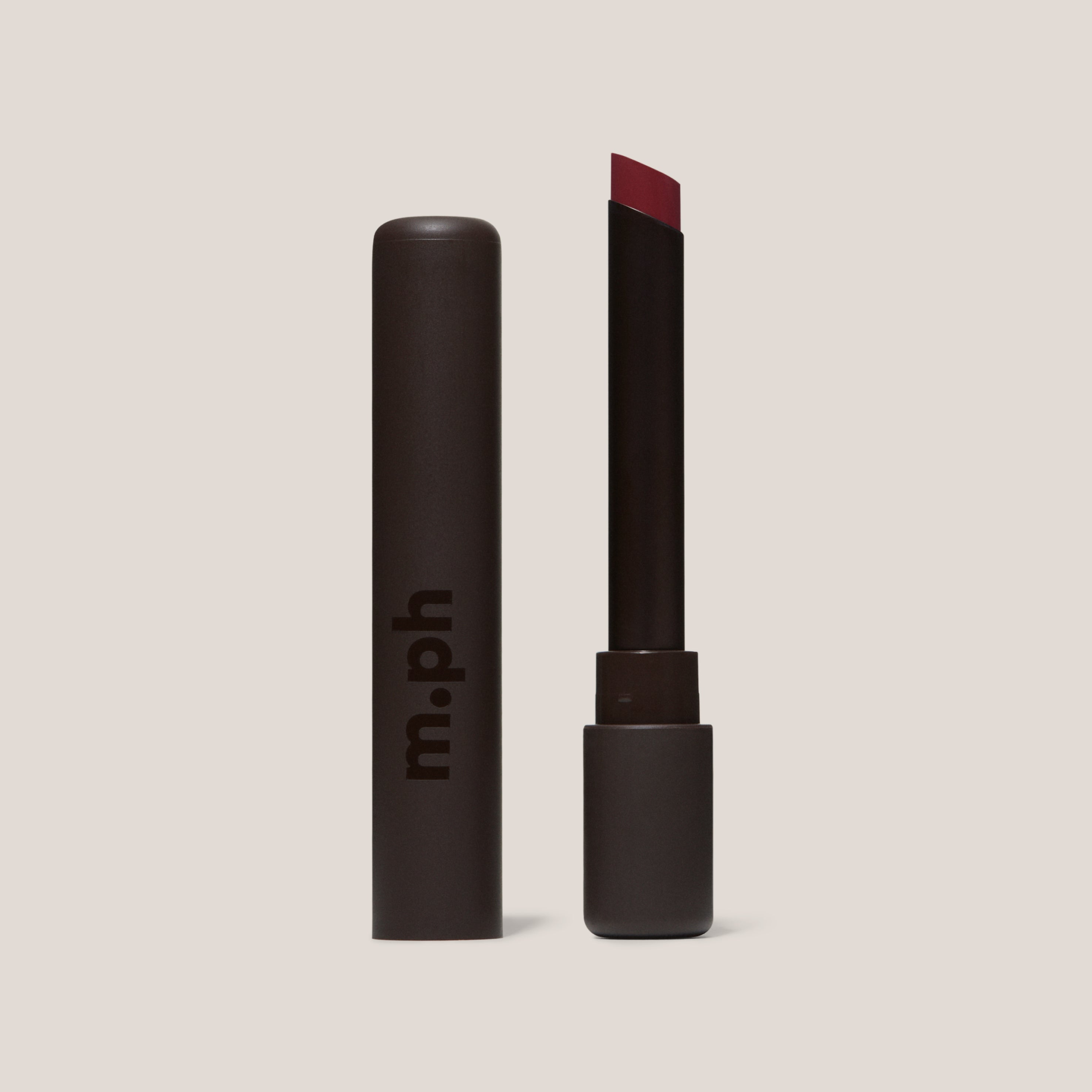 Llipstick with red shade and 'm.ph' branding on a beige background