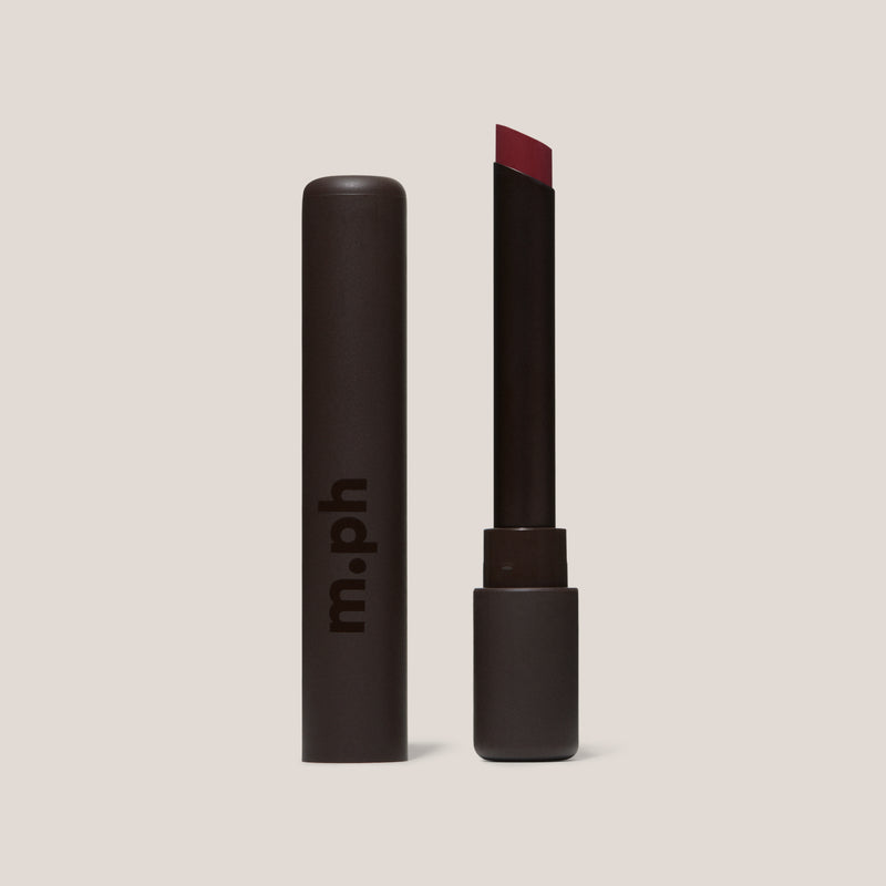 Llipstick with red shade and 'm.ph' branding on a beige background