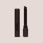 Red lipstick in black package on a white background