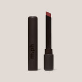 Lipstick with black casing and visible brand 'm.ph' on a beige background