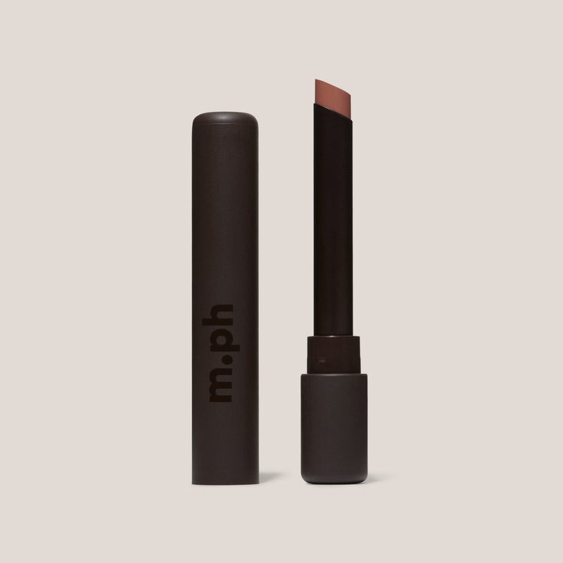 Pink lipstick with open cap on a beige background