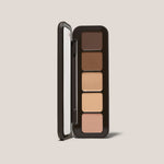 Open Underpainting face palette in medium with five cream contour and highlight shades beside mirror.